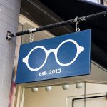 optometry glasses retail store simple modern outdoor hanging sidewalk sign