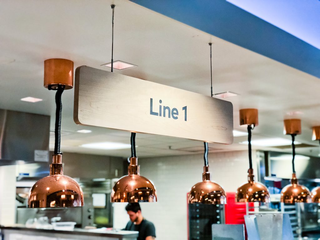 Suspended wood signage for the cafeteria of Thumbtack, an online service that matches customers with local professionals.