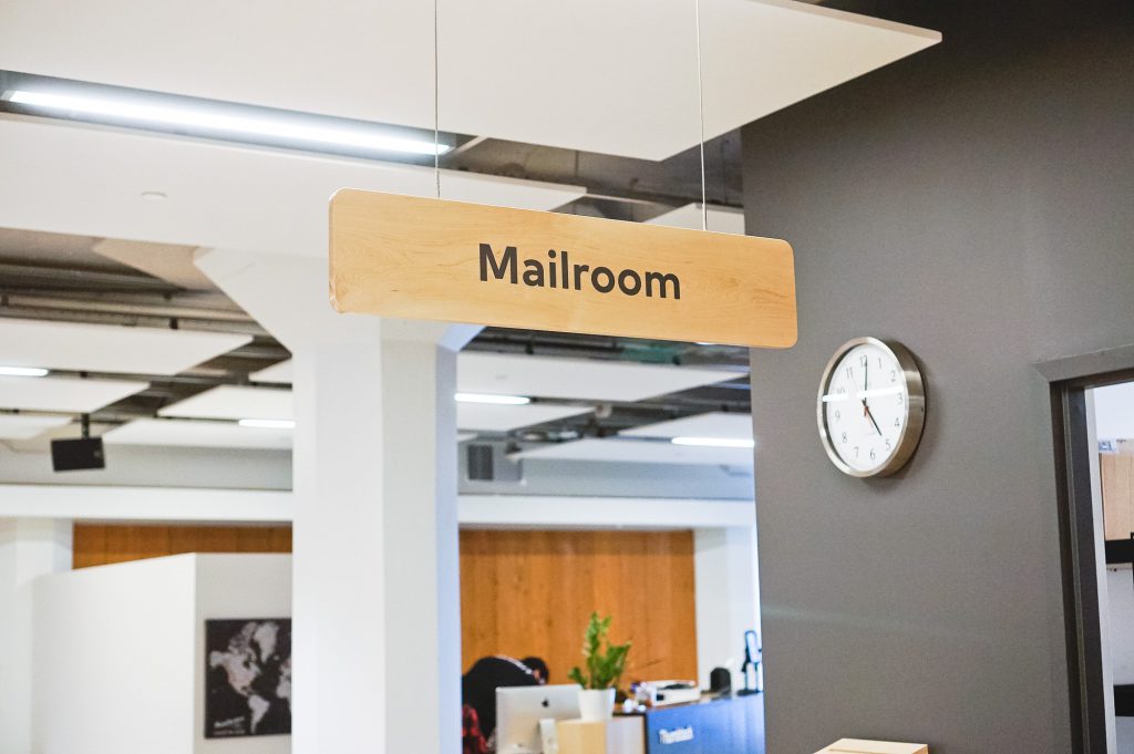 Overhead, light wood wayfinding sign for Thumbtack's special events around the country.