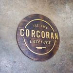 Rustic natural round raised torched wood and gold sign for Corcoran Caterers