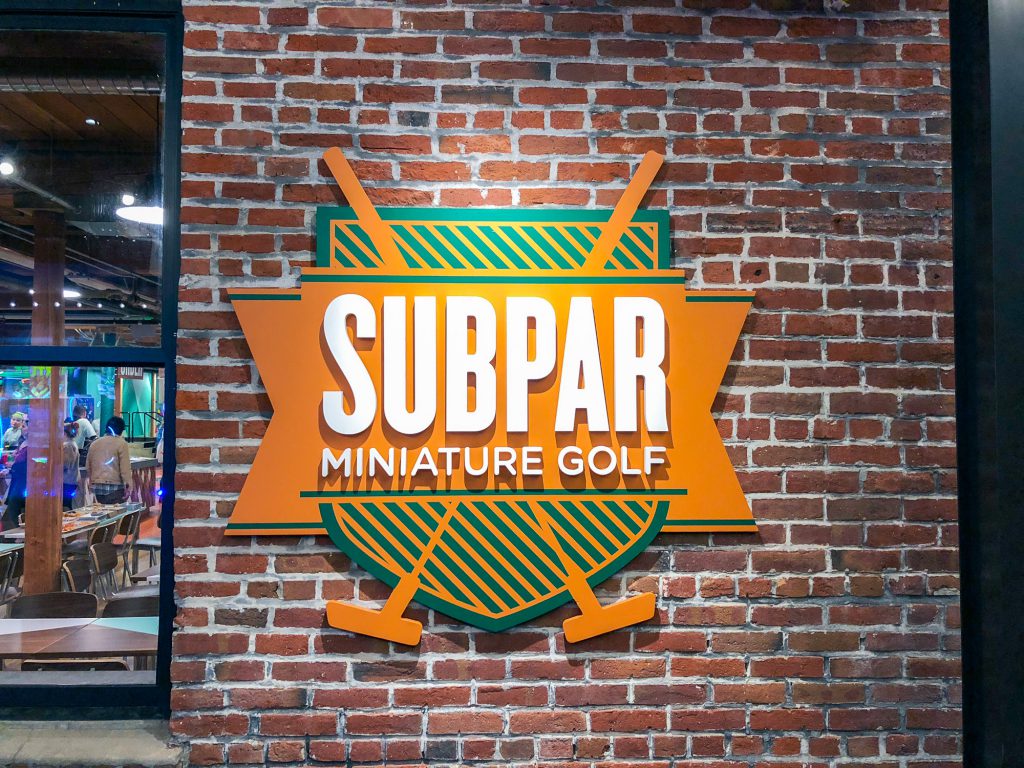 Subpar Mini Golf colorful painted sign on brick wall