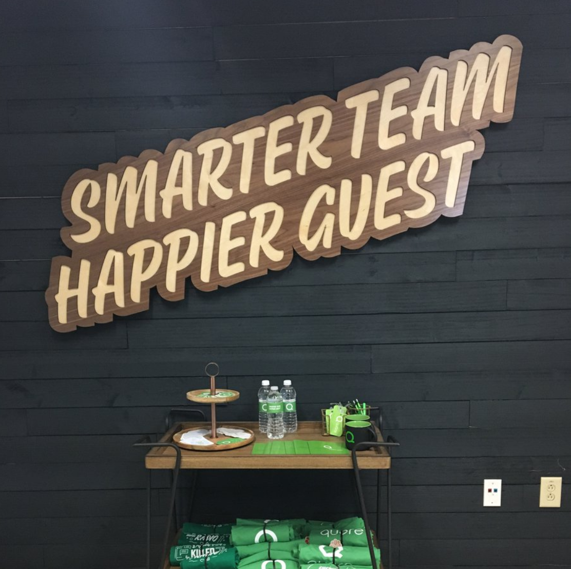 Wood script team motto sign for accent office wall at Quore, a company that crease asset management software for hotel operations. Wood script team motto sign for accent office wall at Quore, a company that crease asset management software for hotel operations.