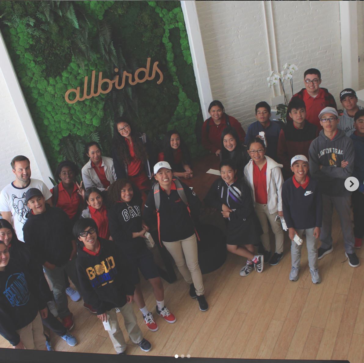 Group posing with light wood script sign on moss wall at Allbirds, a San Francisco-based direct-to-consumer startup aimed at designing environmentally friendly footwear. Group posing with light wood script sign on moss wall at Allbirds, a San Francisco-based direct-to-consumer startup aimed at designing environmentally friendly footwear.