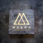 Illuminated, rustic-style, torched wood sign for Magma Creative Studio, a graphic design studio based in Roseville, California.