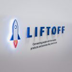 Illuminated rocket logo sign for Liftoff, a company that creates a mobile app optimization marketing platform. Office designed by Knotel, an office space rental agency.
