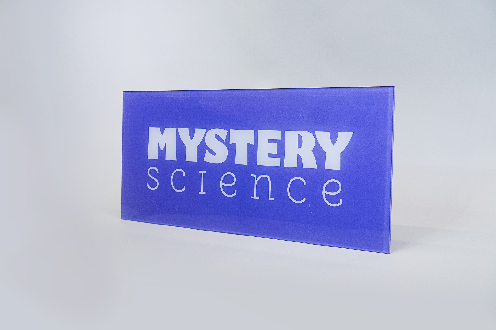 Glass-like colored panel sign for the Knotel designed Mystery Science lobby, a company that provides open-and-go lessons that inspire kids to love science.