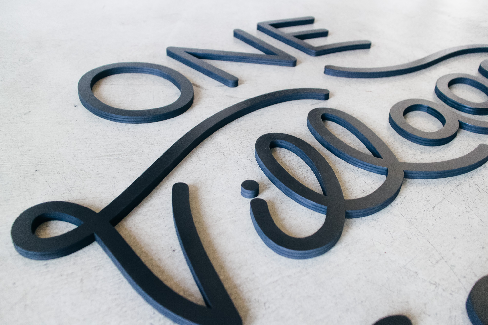Black script sign for One Village Coffee, a specialty coffee roaster based in Souderton, PA.