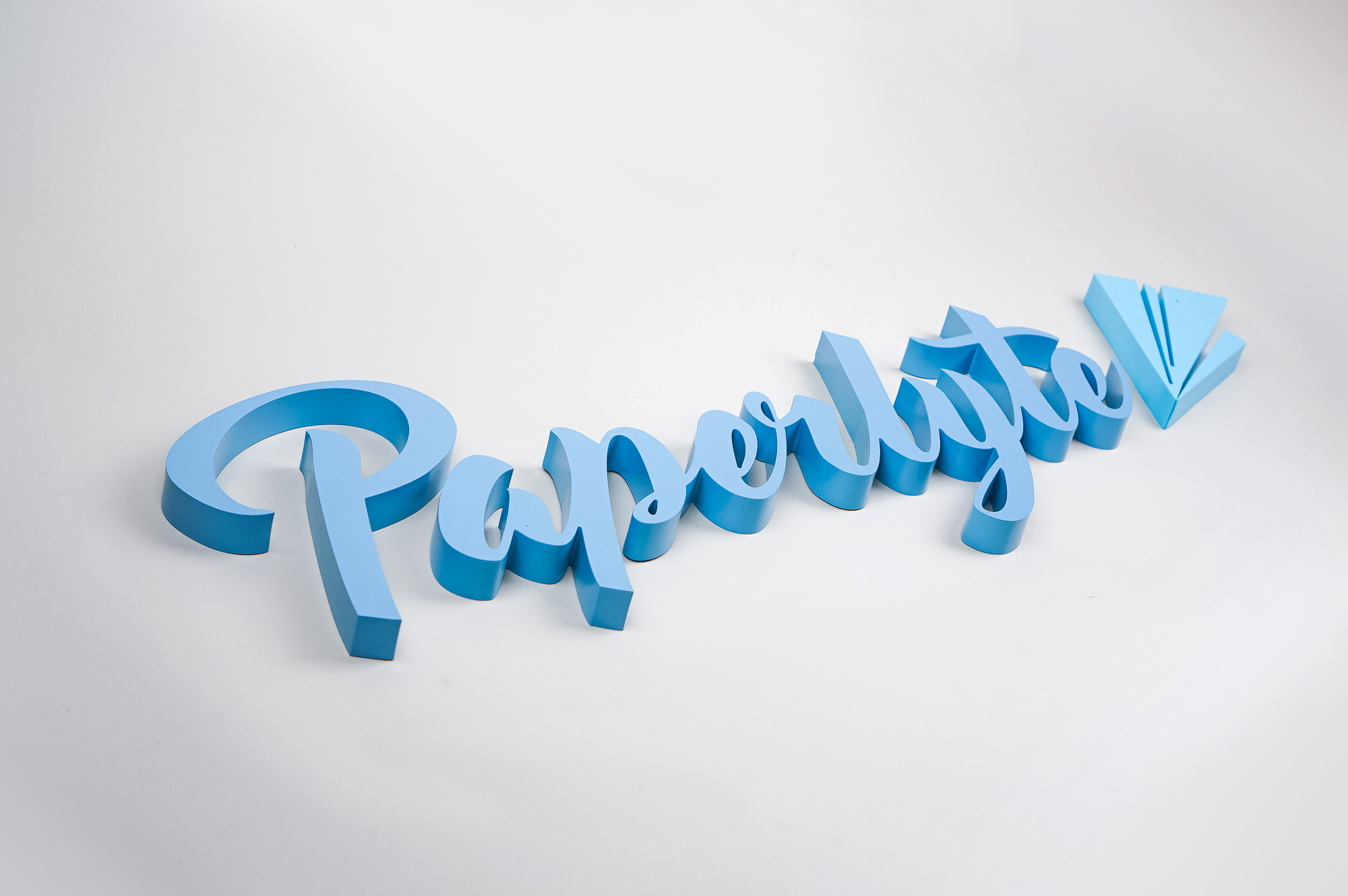 Blue dimensional script sign for Paperlyte, a media production company specializing in live streaming, video, documentary, and commercial content.