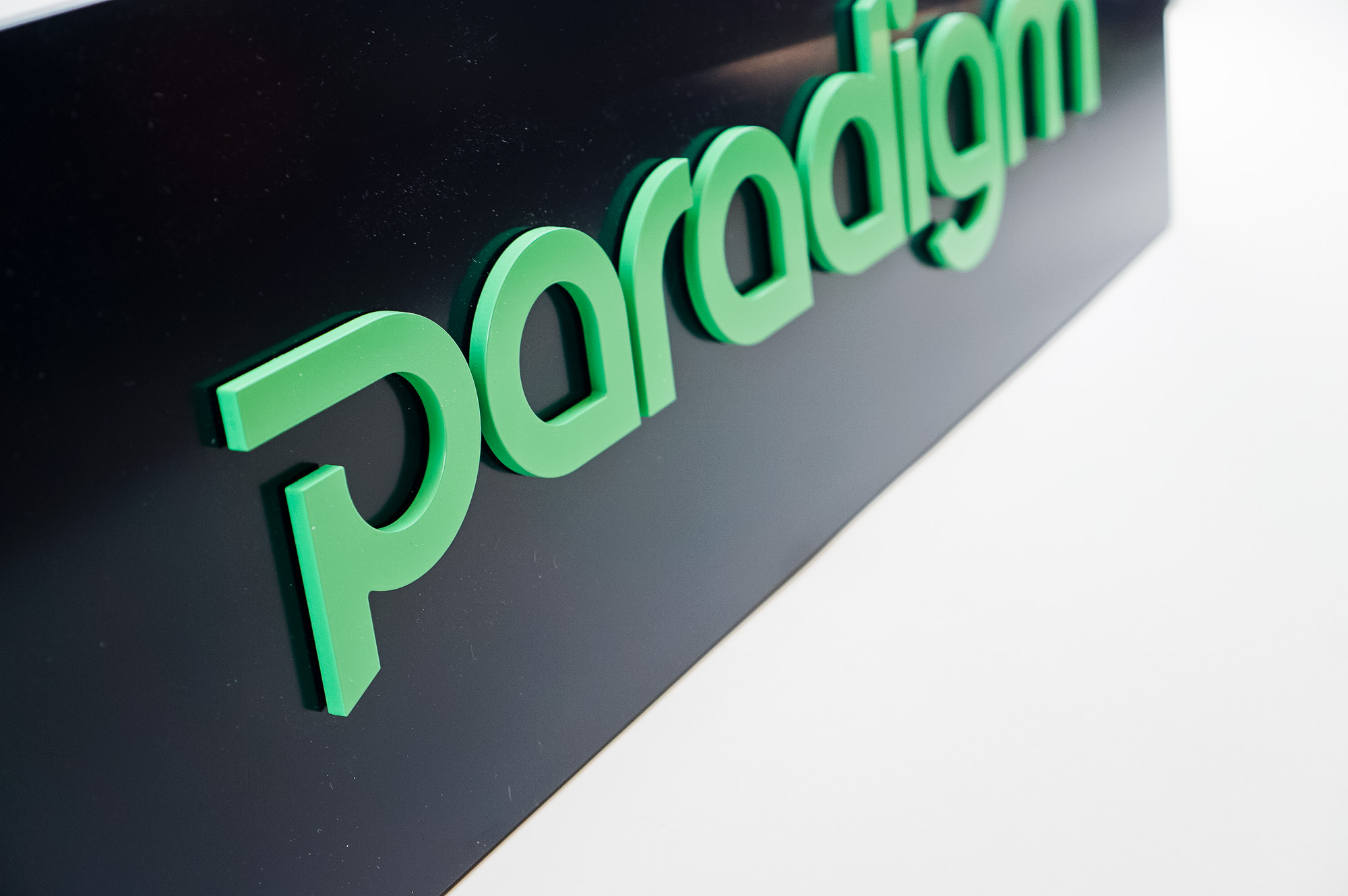 Green and navy, modern, raised text panel sign for Paradigm, a tech company currently located at WeWork in Oakland, CA.