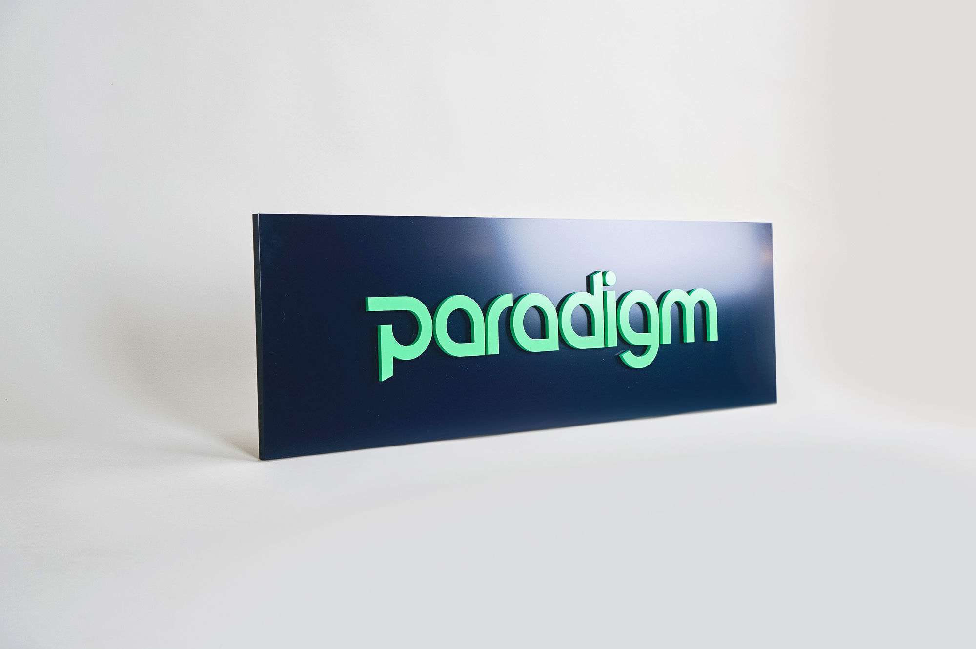 Green and navy, modern, raised text panel sign for Paradigm, a tech company currently located at WeWork in Oakland, CA.