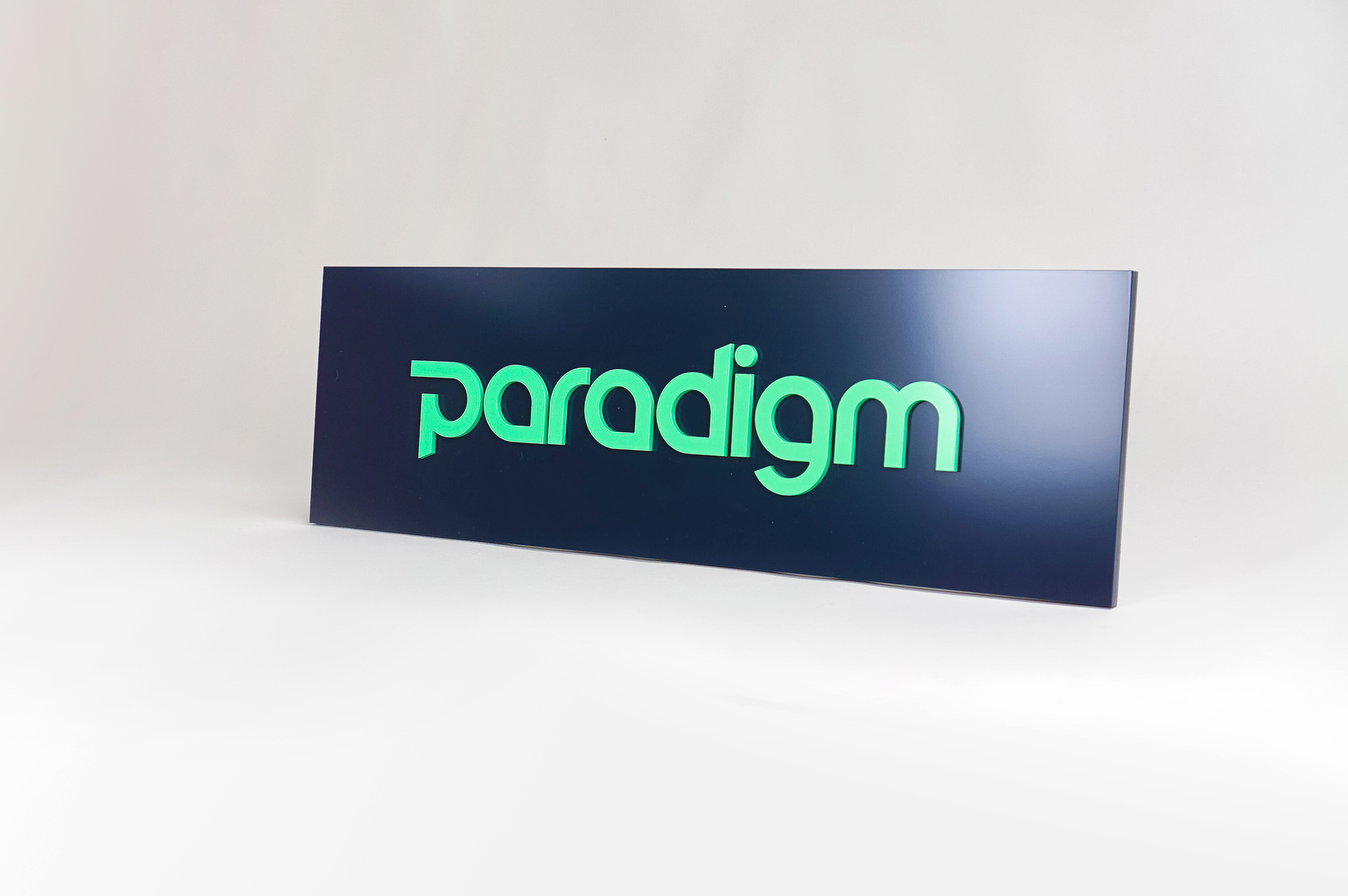 Green and navy, modern, raised text panel sign for Paradigm, a tech company currently located at WeWork in Oakland, CA.
