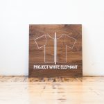 Solid walnut sign with white artwork for Project White Elephant, a womenswear brand based in San Francisco, California.