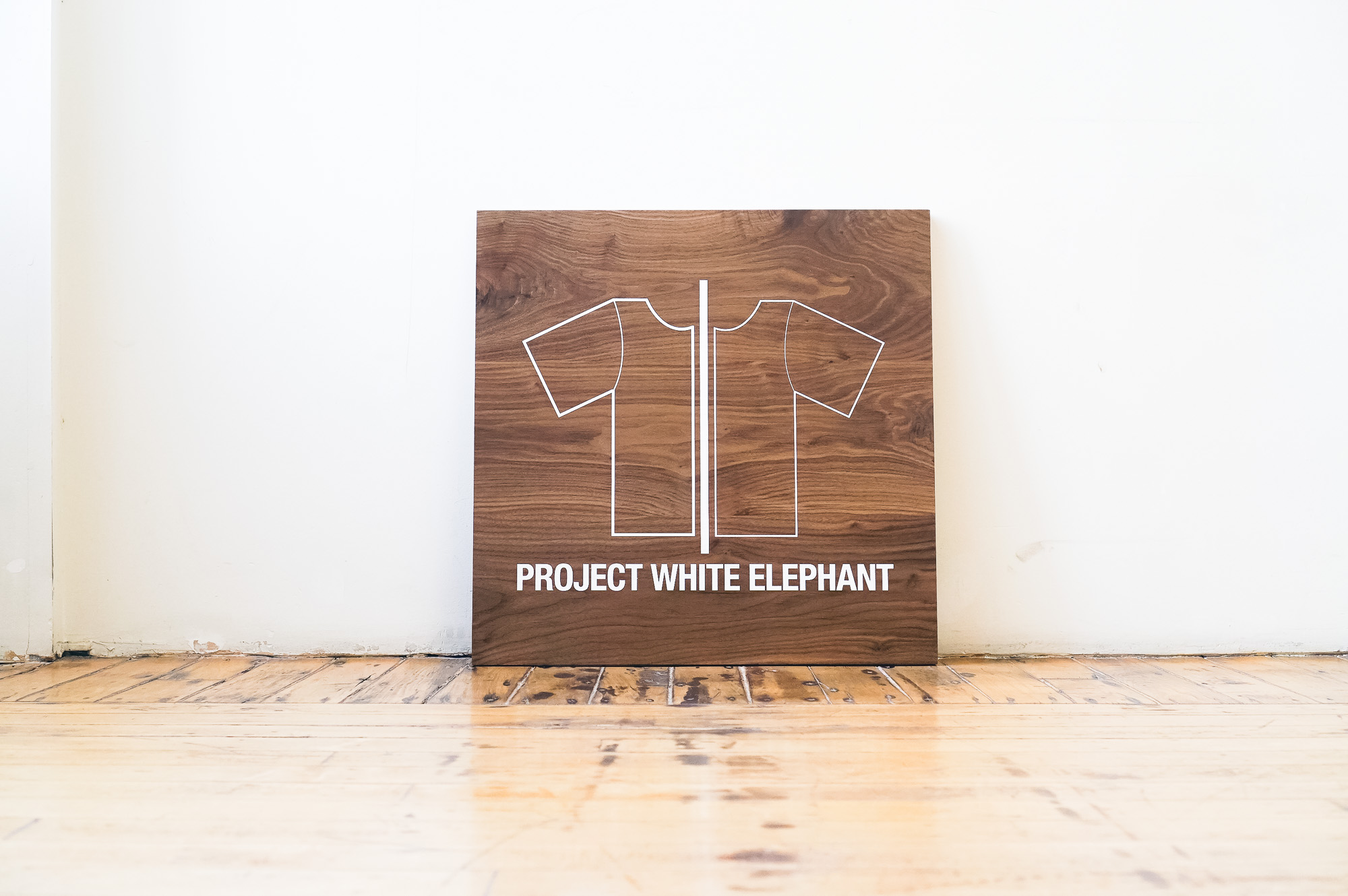 Solid walnut sign with white artwork for Project White Elephant, a womenswear brand based in San Francisco, California. Solid walnut sign with white artwork for Project White Elephant, a womenswear brand based in San Francisco, California.