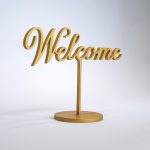 Brushed gold, free-standing welcome sign in script for the entrance at The Wing SF, a co-working space for women.