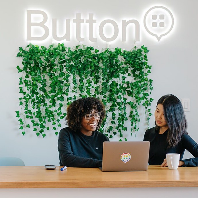 Illuminated, white halo-lit sign on white wall for Button