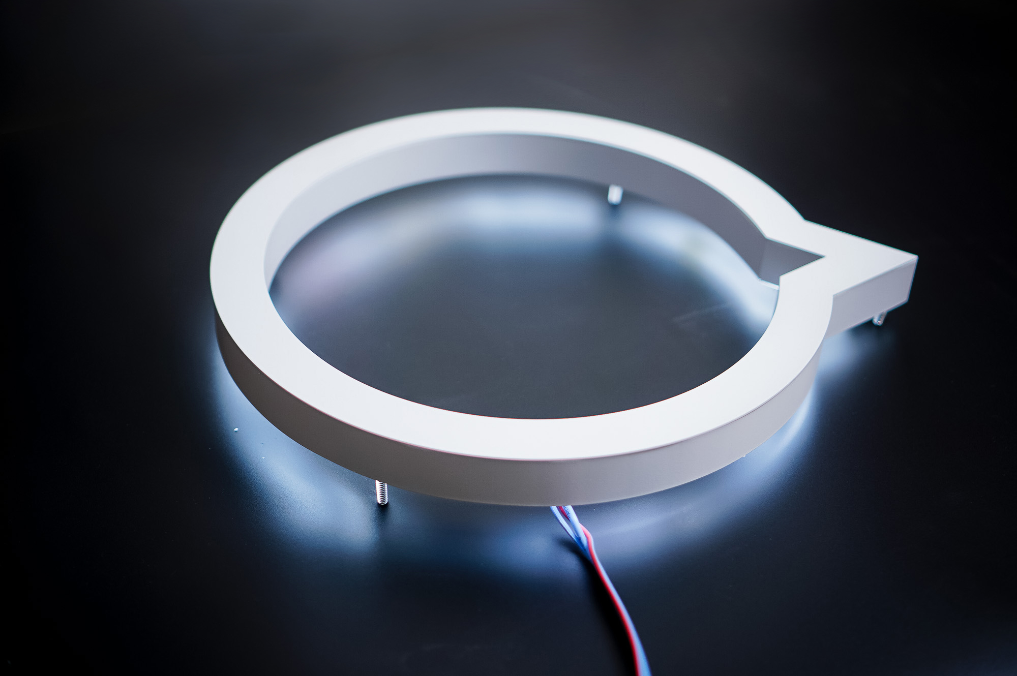 White halo lit illuminated sign for Button, a company that powers mobile partnerships.