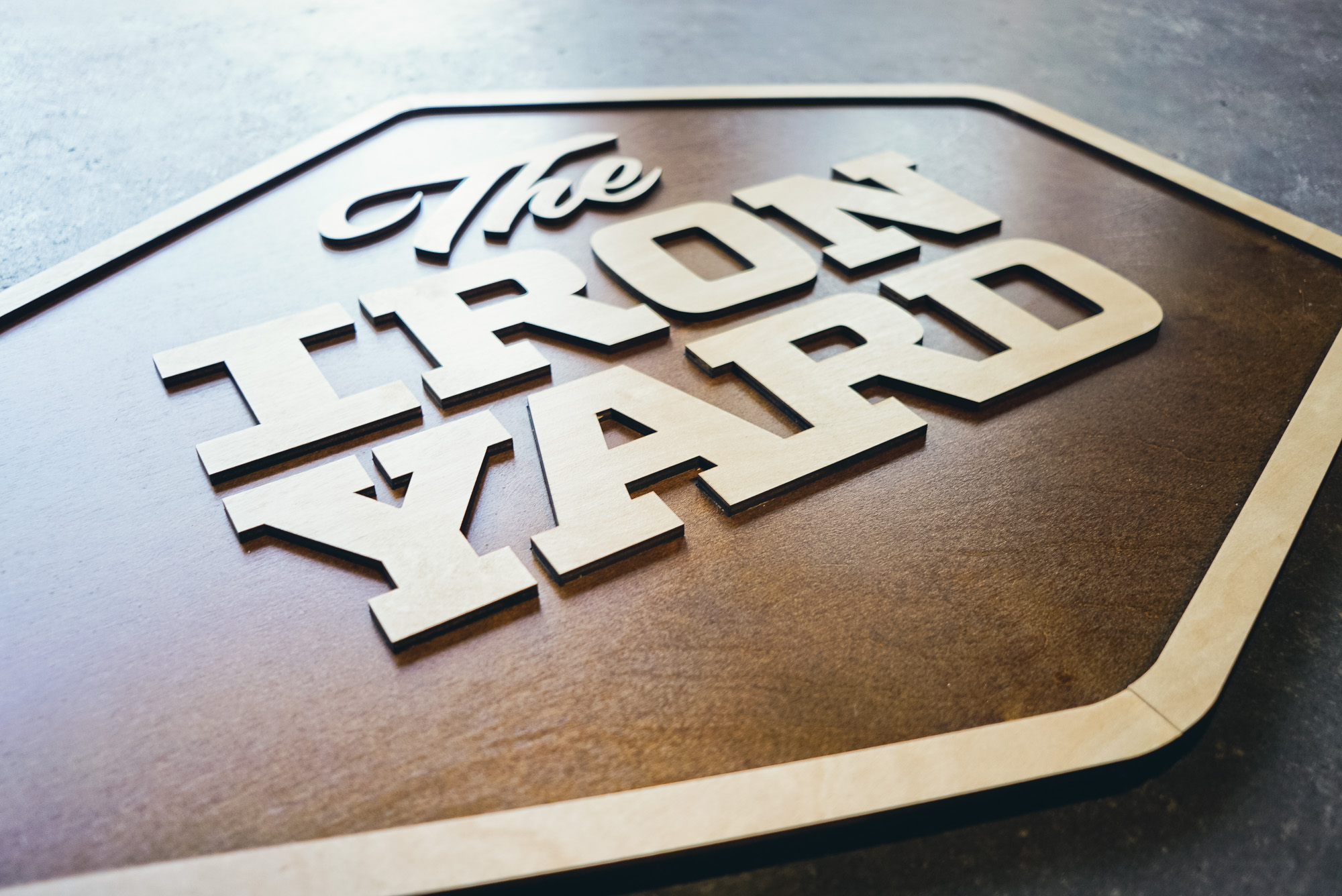 Raised two-toned wood sign for The Iron Yard, a 12-week coding school offered in multiple cities across the US and in London.