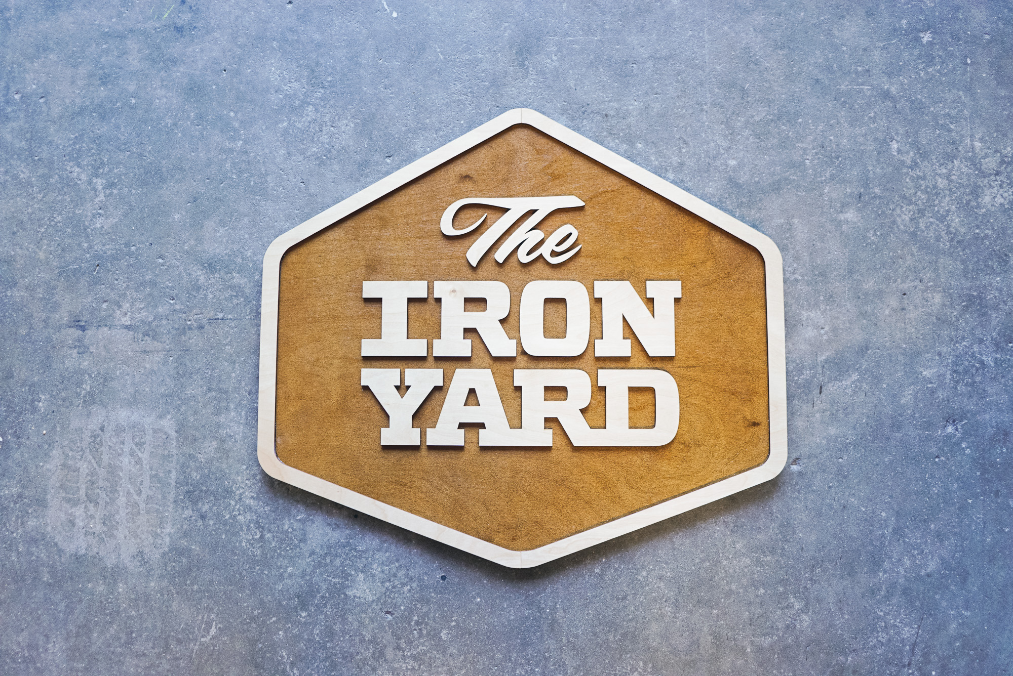 Raised two-toned wood sign for The Iron Yard, a 12-week coding school offered in multiple cities across the US and in London.