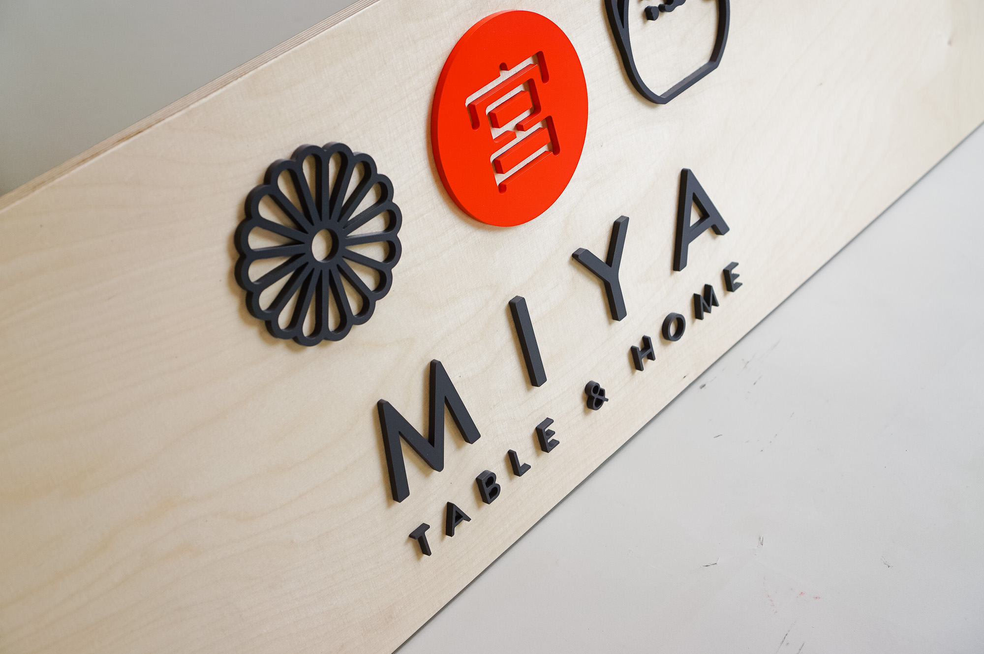 Raised black, red, and light wood sign with icons for Miya Table & Home, a third-generation family owned business, importing Japanese tableware and gifts since 1947. Raised black, red, and light wood sign with icons for Miya Table & Home, a third-generation family owned business, importing Japanese tableware and gifts since 1947.