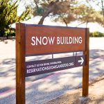 Wood national park style post sign for the snow building at the Oakland Zoo