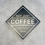 Black and light wood sign for Not Just Coffee