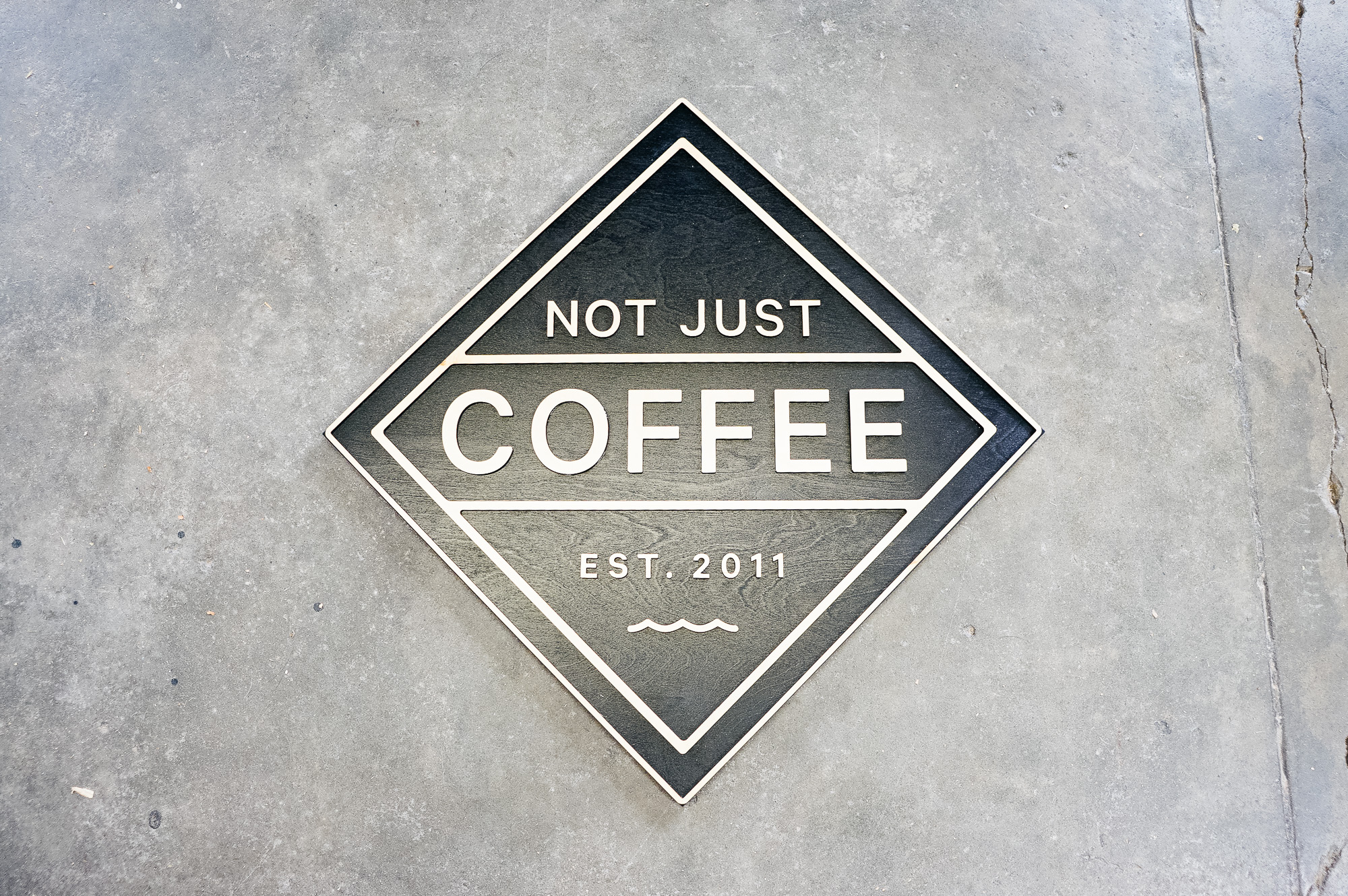 Black and light wood sign for Not Just Coffee Black and light wood sign for Not Just Coffee