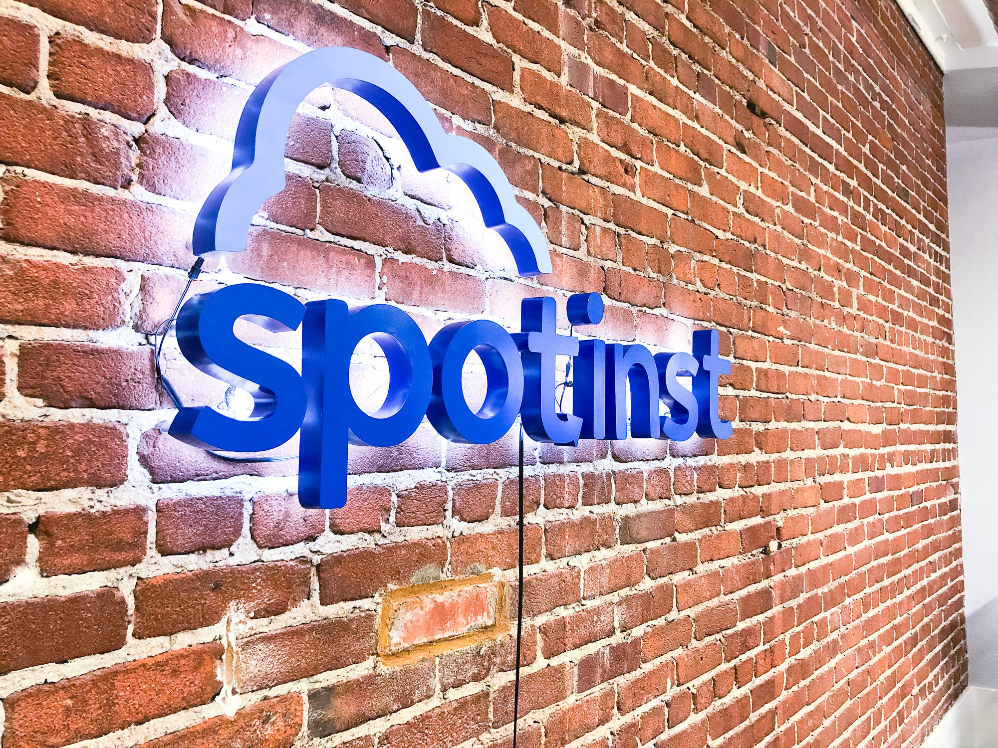 Illuminated, painted blue sign on brick conference room wall for Spotinst, a San Francisco company that creates intelligent workload software. Illuminated, painted blue sign on brick conference room wall for Spotinst, a San Francisco company that creates intelligent workload software.