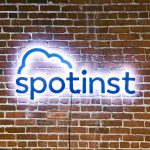 Illuminated, painted blue sign on brick conference room wall for Spotinst, a San Francisco company that creates intelligent workload software.