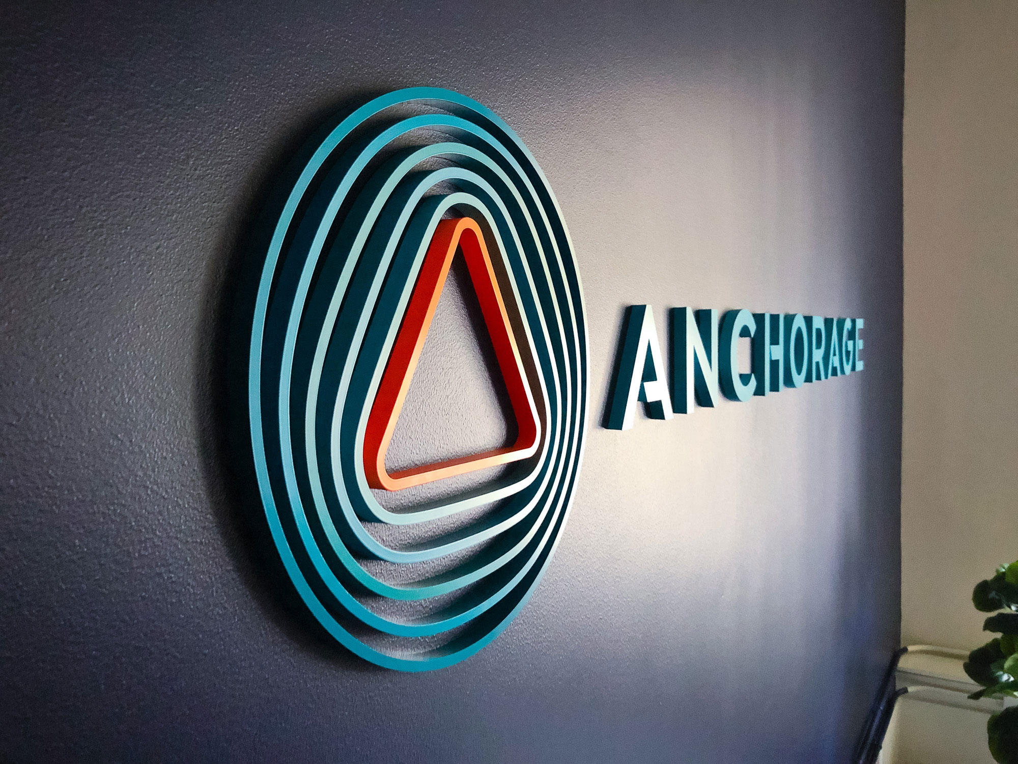Painted, multi-color acrylic sign on a dark, navy blue wall for the lobby of Anchorage, a San Francisco-based company focused on creating custody solutions for the cryptocurrency ecosystem.