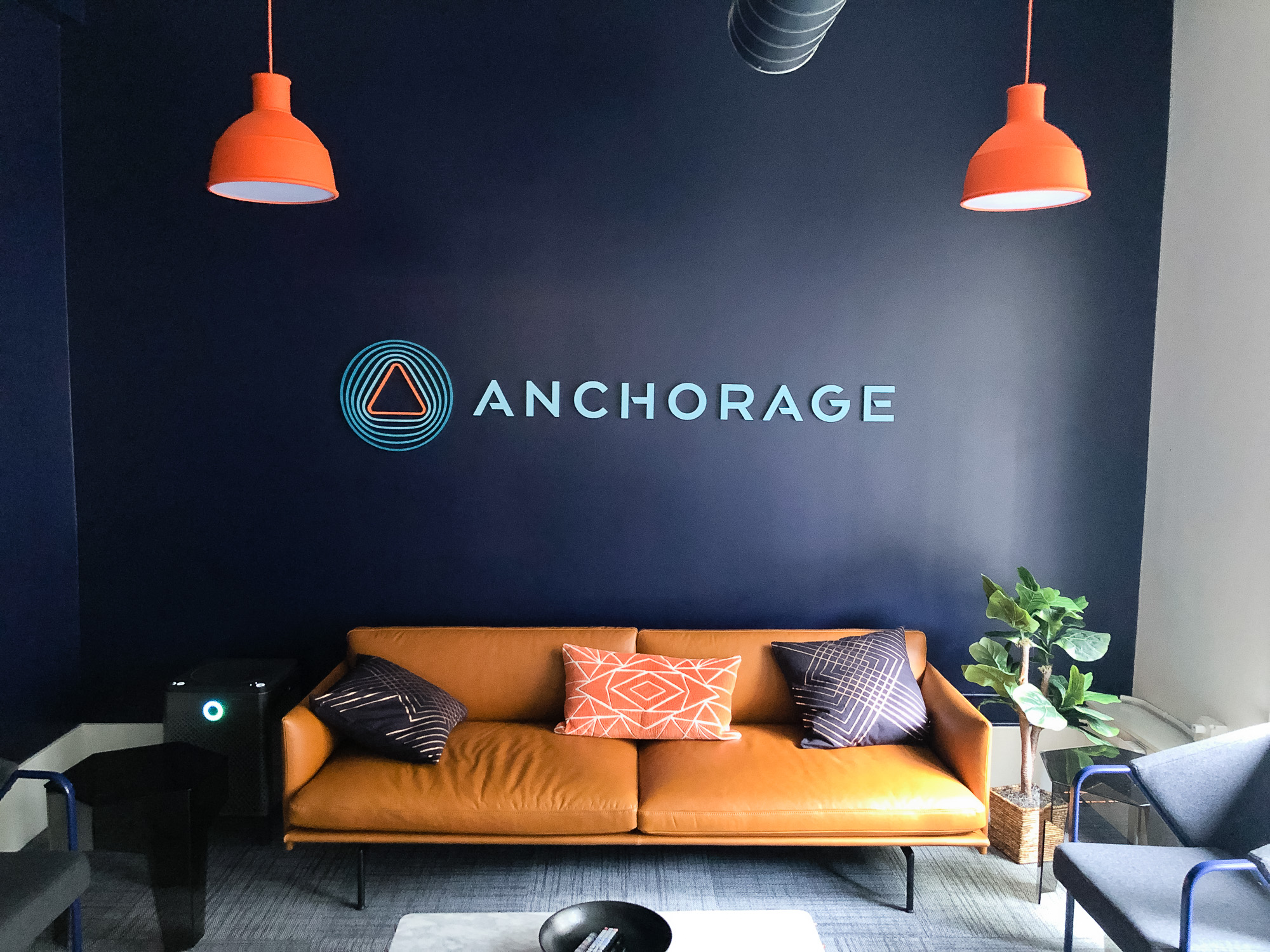 Painted, multi-color acrylic sign on a dark, navy blue wall for the lobby of Anchorage, a San Francisco-based company focused on creating custody solutions for the cryptocurrency ecosystem.