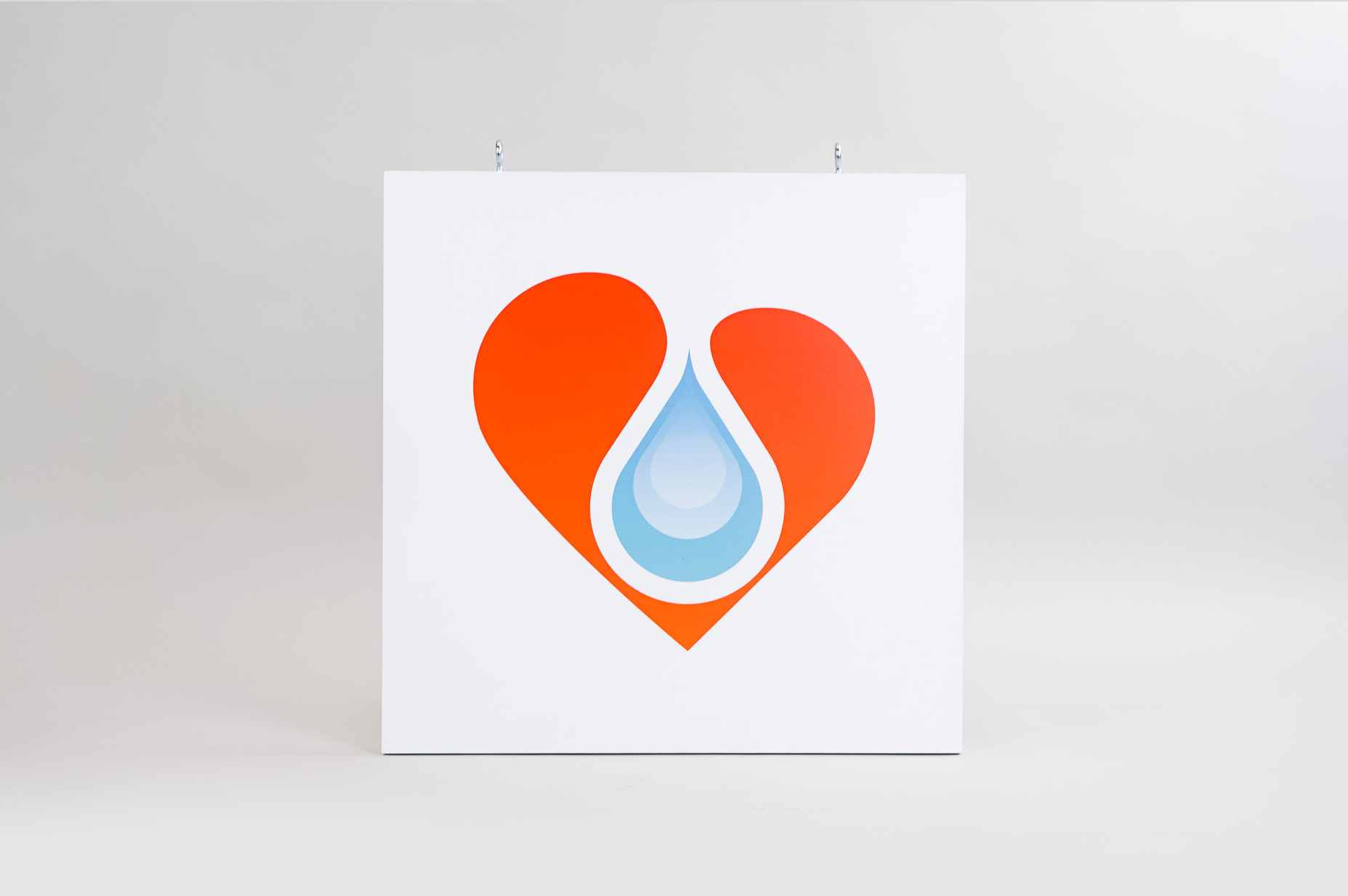 White hanging blade sign with colored logo for B12 LOVE, a San Francisco center offering nutrient therapies.