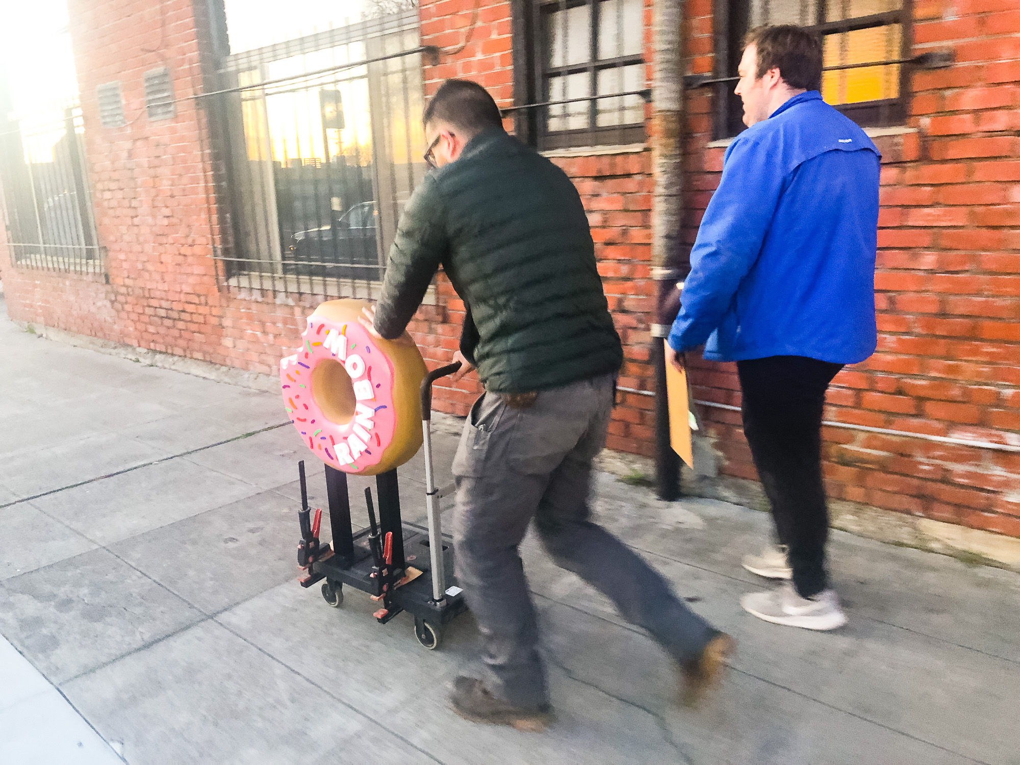 Delivering a 3D, pink-frosted, sculptural, sprinkle donut blade sign for Rainbow Donuts in Berkeley, CA