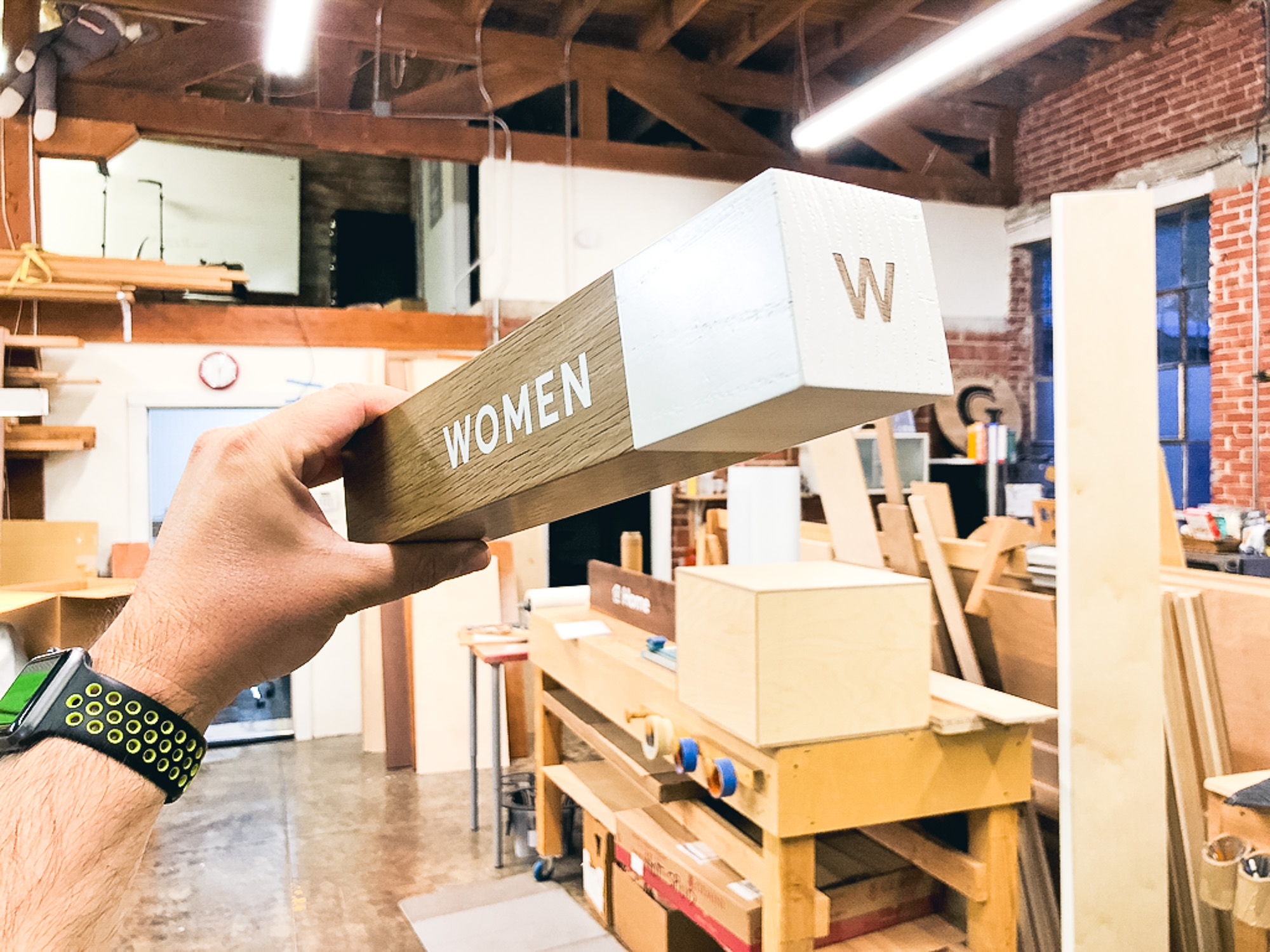 White-painted wood, national park-inspired, overhead wayfinding sign for the office of Slack, a cloud-based set of proprietary team collaboration tools and services. White-painted wood, national park-inspired, overhead wayfinding sign for the office of Slack, a cloud-based set of proprietary team collaboration tools and services.