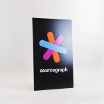 Simple black blade sign with colored logo for Sourcegraph, a San Francisco-based company that adds code intelligence to GitHub and other code hosts.