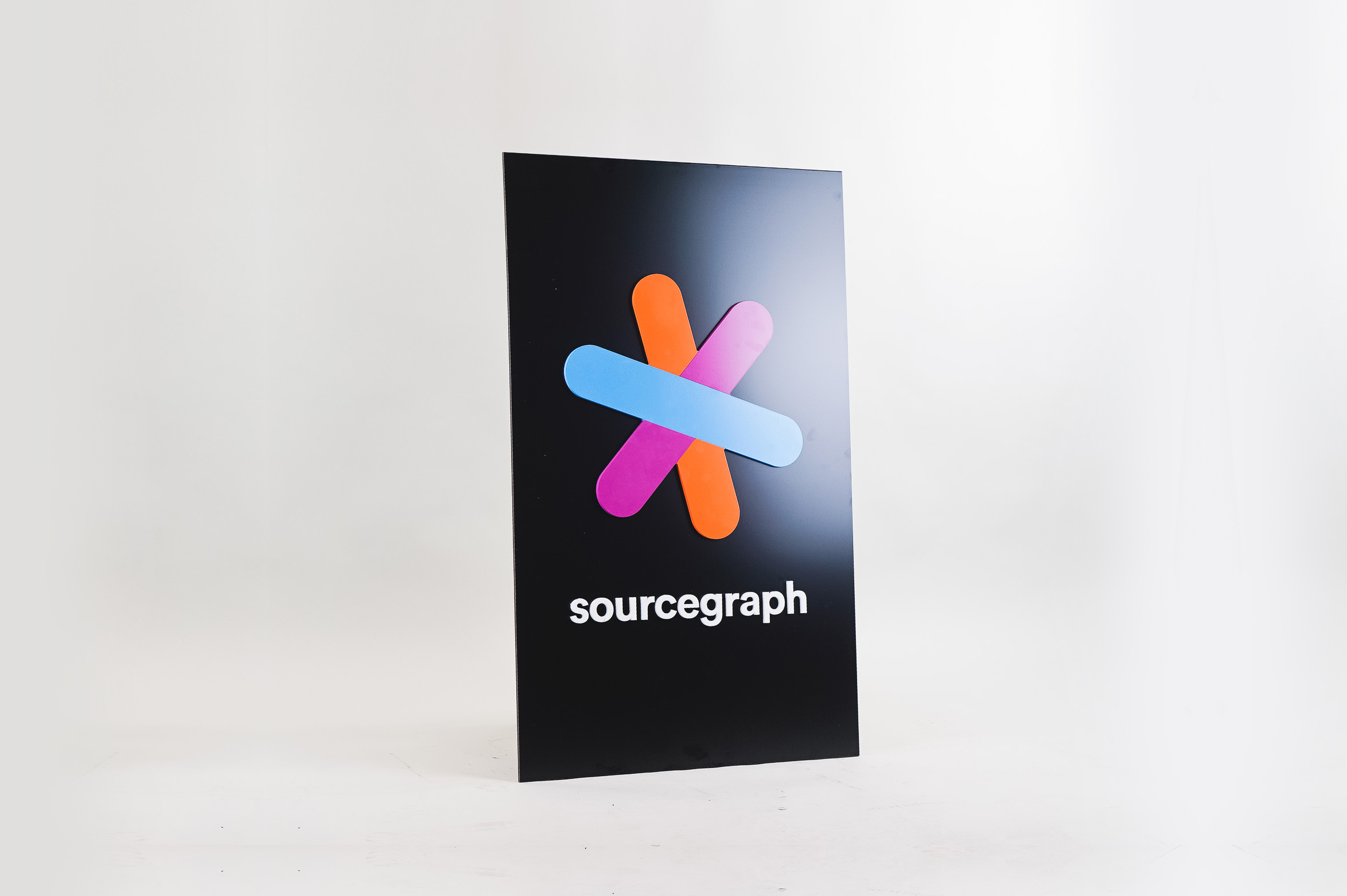 Simple black blade sign with colored logo for Sourcegraph, a San Francisco-based company that adds code intelligence to GitHub and other code hosts. Simple black blade sign with colored logo for Sourcegraph, a San Francisco-based company that adds code intelligence to GitHub and other code hosts.