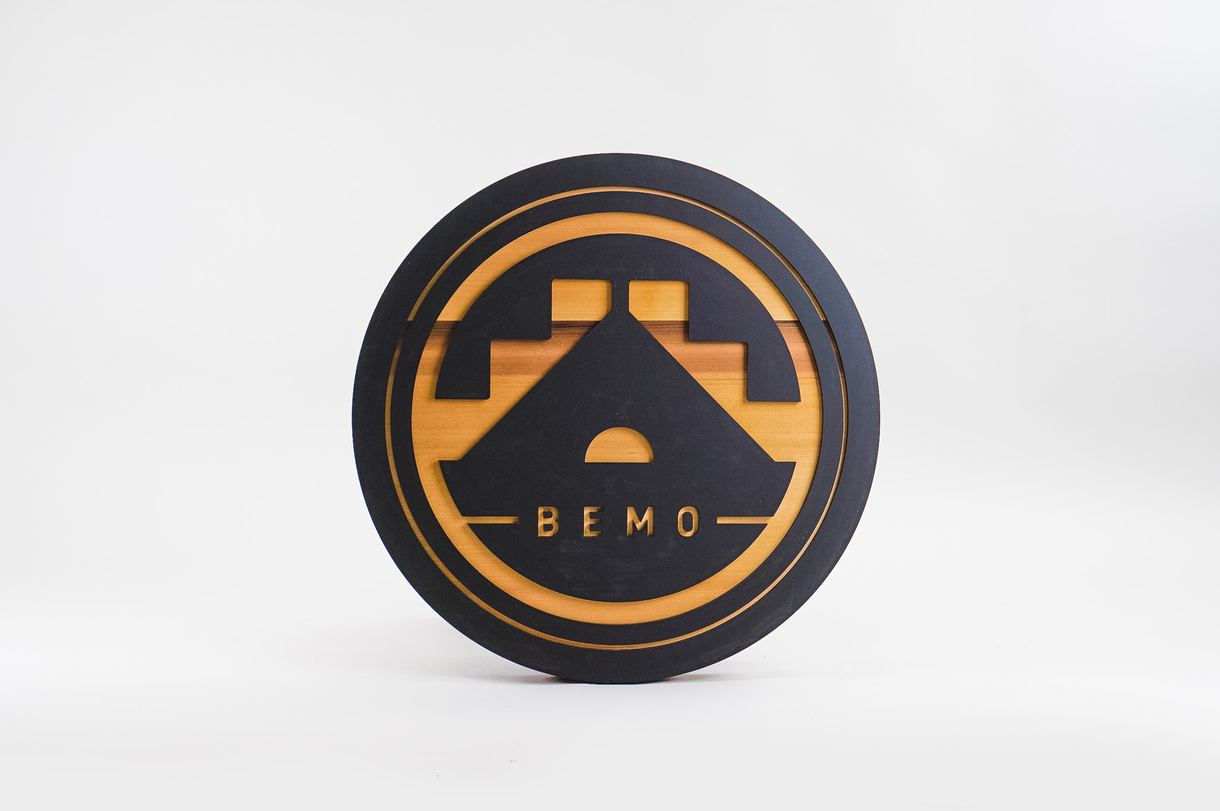Raised matte black and cedar round exterior sign for BEMO, a Los Angeles based creative studio specializing in VFX, Animation and Immersive Content.