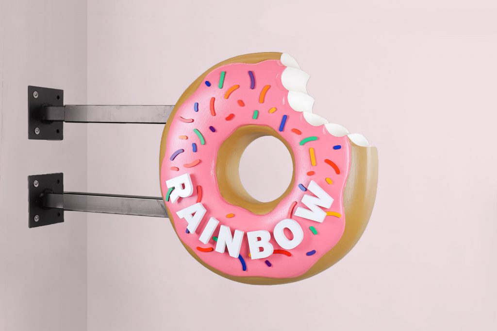 3D, pink-frosted, sculptural, sprinkle donut blade sign for Rainbow Donuts in Berkeley, CA