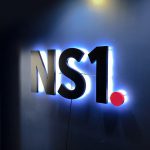 NS1 halo lit sign on dark blue wall