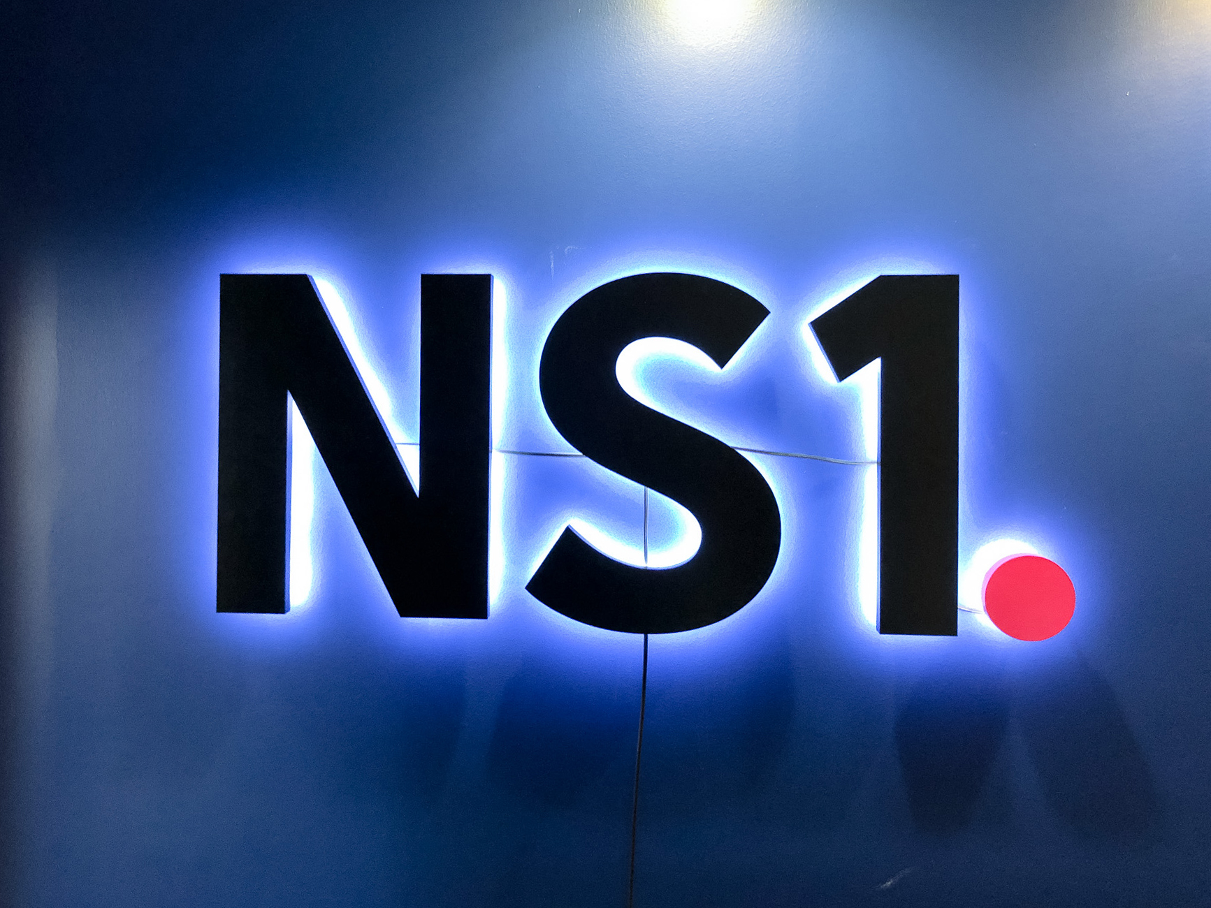 NS1 halo lit sign on dark blue wall