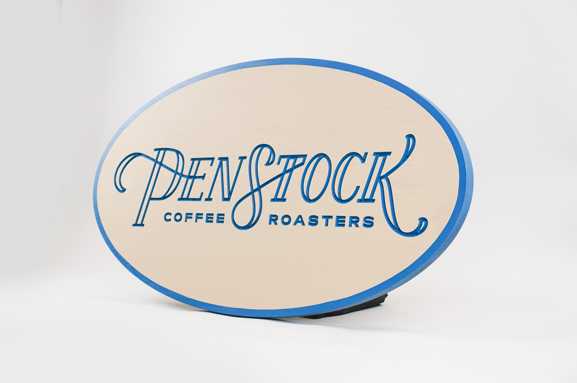 Blue and light wood engraved sign for Penstock Coffee Roasters, a coffee roastery and specialty coffee shop in New Jersey.