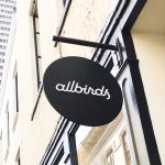 Black round blade sign with white script text for Allbirds, a San Francisco-based direct-to-consumer startup aimed at designing environmentally friendly footwear.