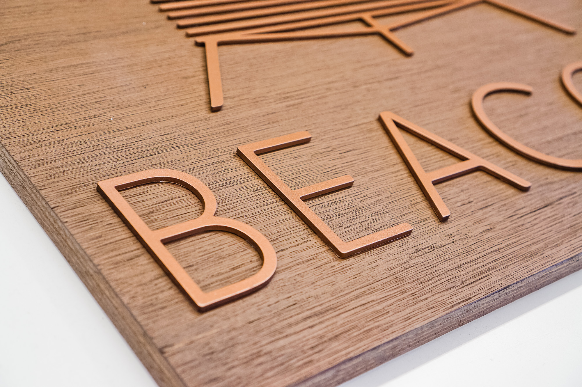 Metallic copper painted acrylic and dark wood outdoor sign for Beacon