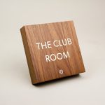 Vintage walnut and inlaid-brass style sign for Nexus Club, a private social and business club in New York.