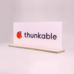 Glass-like, pink freestanding back printed sign for Thunkable, a cross-platform app builder that enables anyone to build their own native mobile apps.