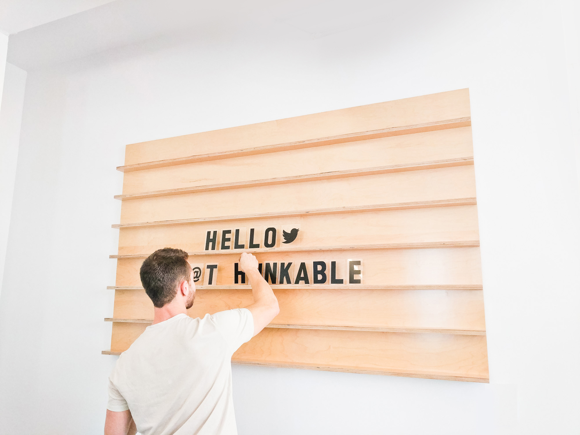Wood message board with rails and clear letters for the office of Thunkable, a cross-platform app builder that enables anyone to build their own native mobile apps.