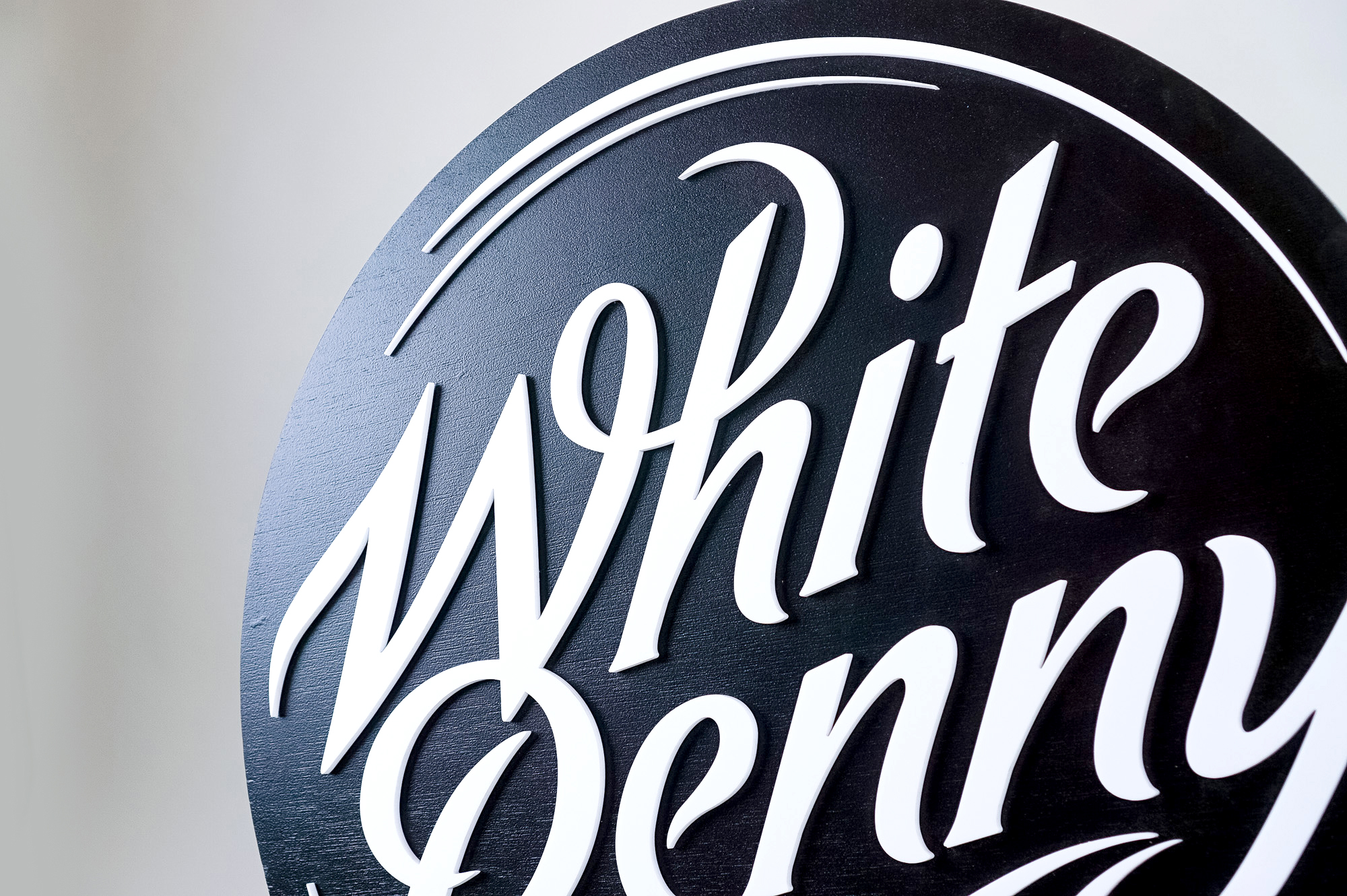 Black and white round raised sign with intricate lettering for Whitepenny, a web development, design and branding firm based in New Jersey. Black and white round raised sign with intricate lettering for Whitepenny, a web development, design and branding firm based in New Jersey.