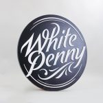 Black and white round raised sign with intricate lettering for Whitepenny, a web development, design and branding firm based in New Jersey.