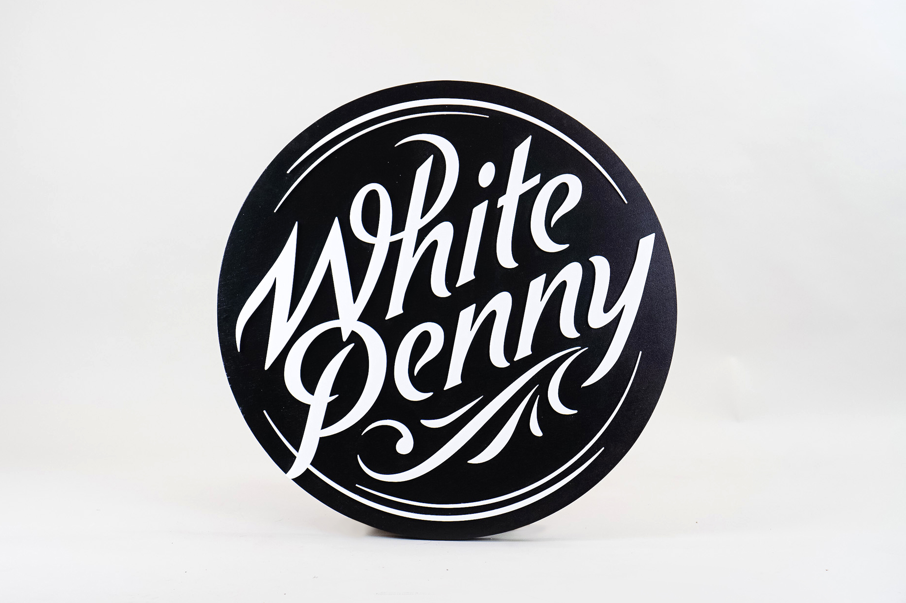 Black and white round raised sign with intricate lettering for Whitepenny, a web development, design and branding firm based in New Jersey. Black and white round raised sign with intricate lettering for Whitepenny, a web development, design and branding firm based in New Jersey.