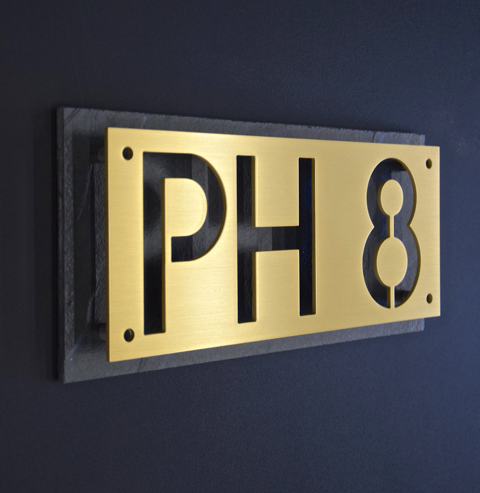 Cutout brass stencil house numbers on black plaque