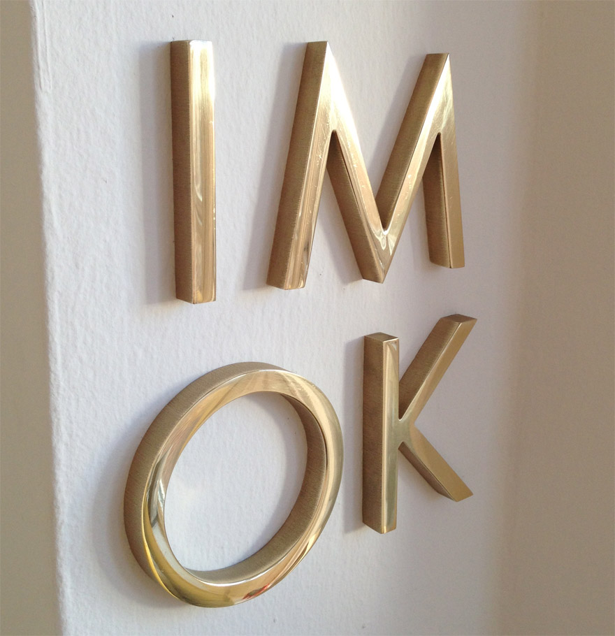 solid brass letters on white wall